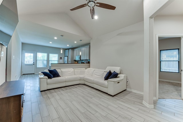 living area featuring light wood finished floors, a ceiling fan, baseboards, recessed lighting, and vaulted ceiling