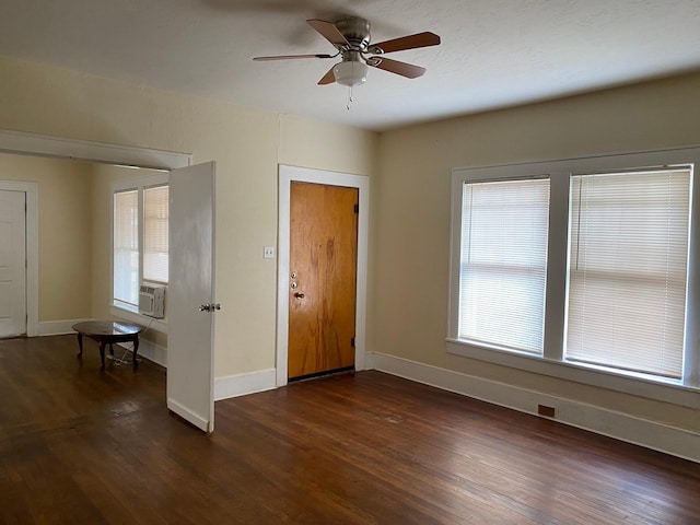 foyer with a ceiling fan, baseboards, and dark wood-style floors