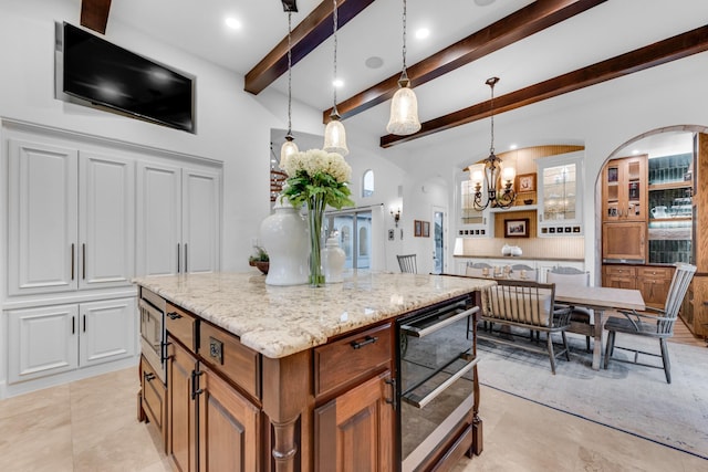 7242 Waters Edge Dr, The Colony, TX 75056 - kitchen with a kitchen island, light stone countertops, beamed ceiling, a notable chandelier, and decorative light fixtures