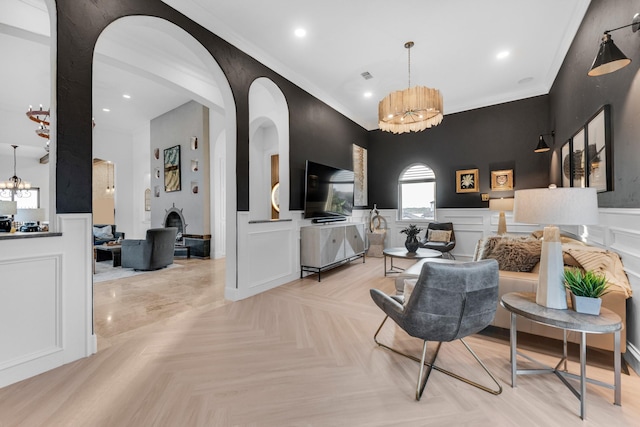 7242 Waters Edge Dr, The Colony, TX 75056 - living area with crown molding, a wainscoted wall, arched walkways, and a notable chandelier