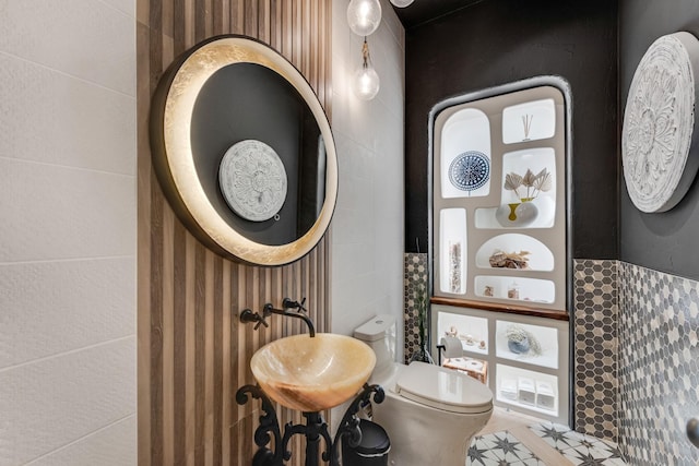 7242 Waters Edge Dr, The Colony, TX 75056 - half bathroom featuring a sink, tile walls, and toilet