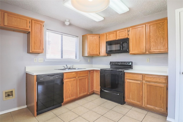 kitchen featuring light countertops, a textured ceiling, a sink, and black appliances