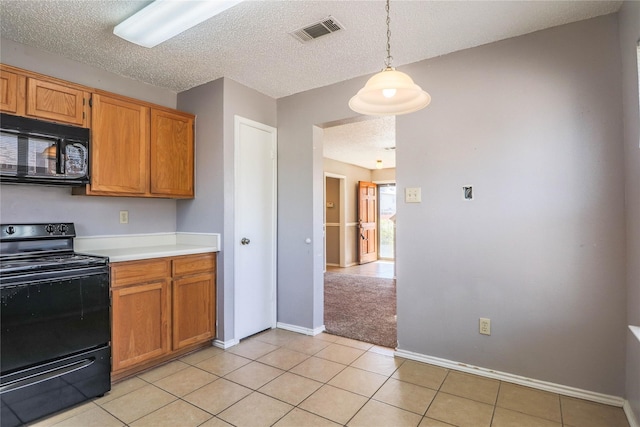 kitchen featuring visible vents, brown cabinets, light countertops, baseboards, and black appliances