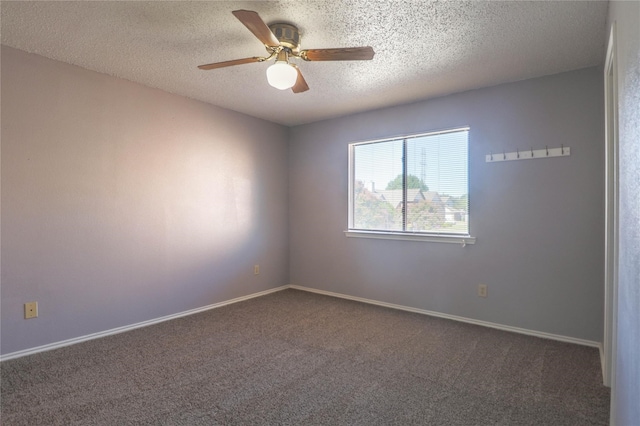 unfurnished room with baseboards, ceiling fan, dark carpet, and a textured ceiling