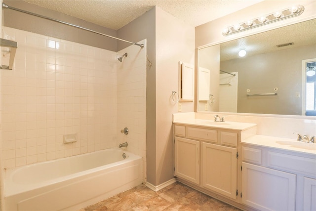 bathroom with a textured ceiling, visible vents, bathing tub / shower combination, and vanity