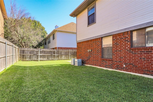 view of yard featuring a fenced backyard and central AC