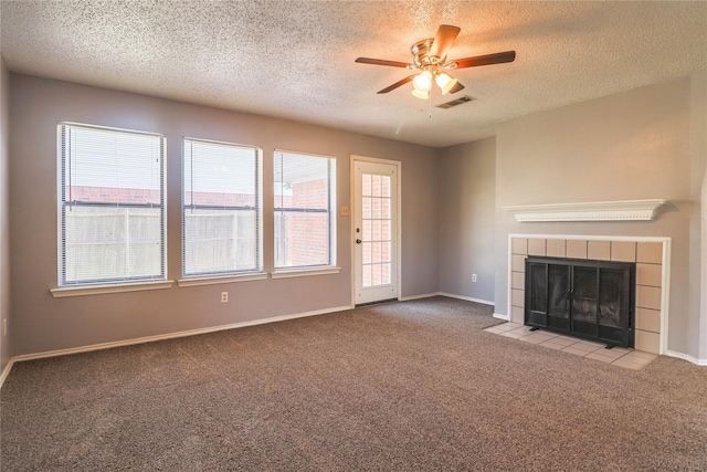 unfurnished living room featuring a fireplace, carpet floors, a textured ceiling, a ceiling fan, and visible vents