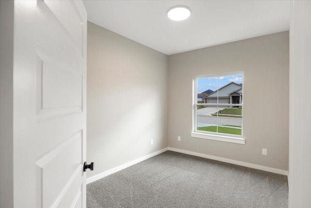 spare room featuring baseboards and carpet flooring