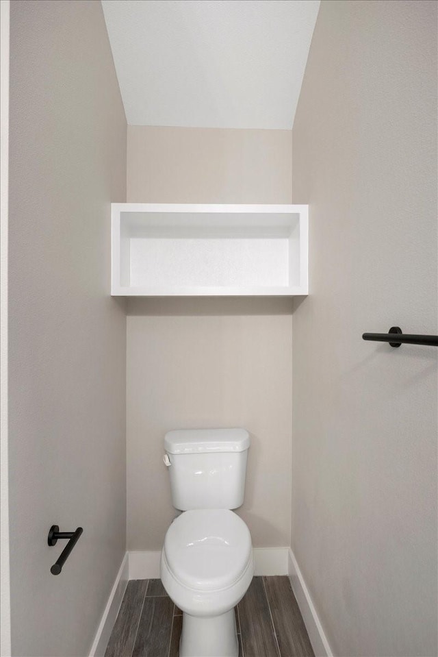 bathroom featuring baseboards, toilet, and wood finished floors
