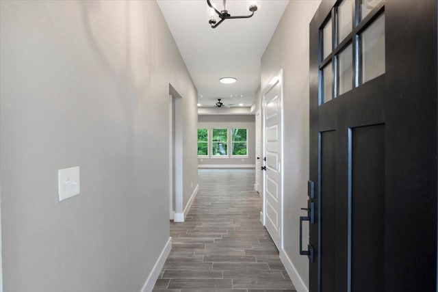 hallway featuring baseboards and wood finished floors