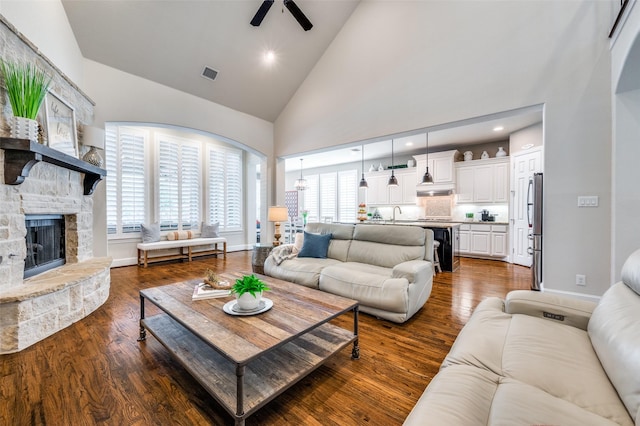 living area featuring a healthy amount of sunlight, high vaulted ceiling, a ceiling fan, and visible vents