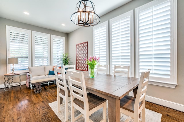 dining area with baseboards, recessed lighting, wood finished floors, and a chandelier