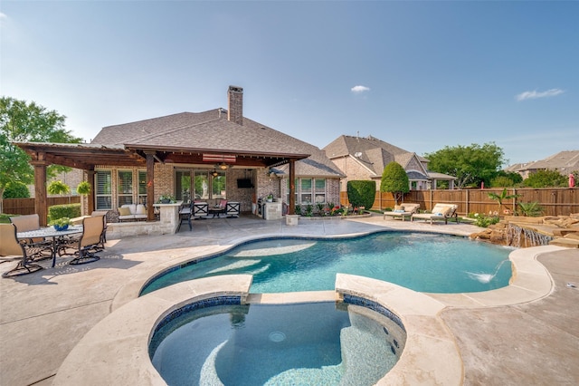 view of swimming pool featuring a patio, a pool with connected hot tub, a fenced backyard, and outdoor dining space