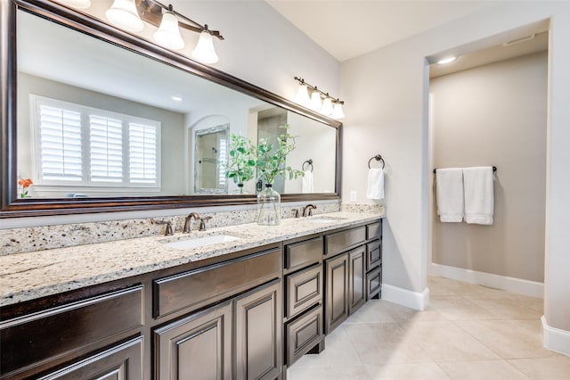 full bath featuring baseboards, a sink, and tile patterned flooring