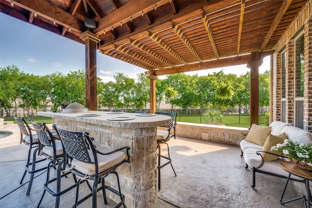 view of patio / terrace featuring outdoor wet bar and fence