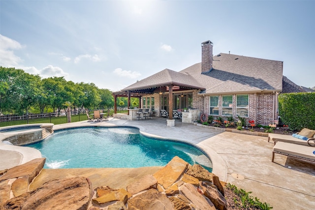 view of swimming pool with a fenced backyard, outdoor dry bar, a patio, and a pool with connected hot tub