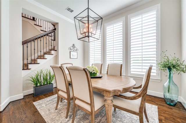 dining space with baseboards, a chandelier, wood finished floors, and stairway