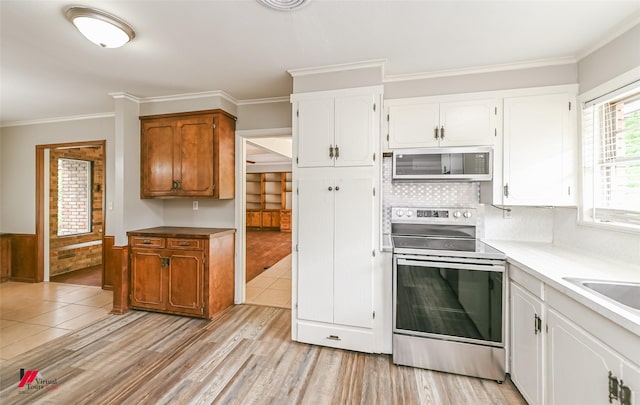 kitchen with ornamental molding, white cabinetry, and stainless steel appliances