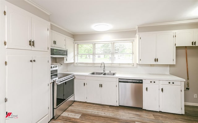 kitchen with appliances with stainless steel finishes, a sink, light countertops, white cabinets, and ornamental molding