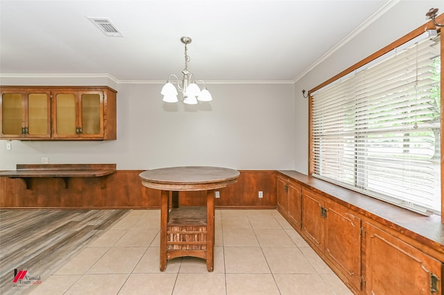 dining room featuring crown molding, light tile patterned flooring, a chandelier, and visible vents