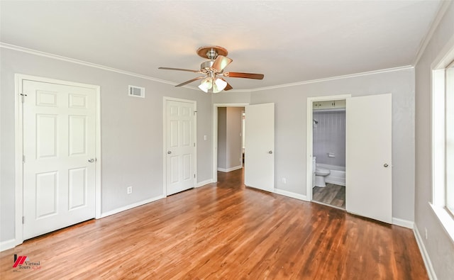 unfurnished bedroom featuring ornamental molding, wood finished floors, and visible vents