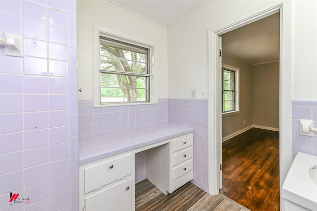 bathroom featuring tile walls, ornamental molding, wood finished floors, and a wealth of natural light