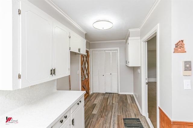 mudroom with crown molding, dark wood-style flooring, and baseboards