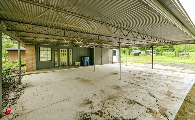 view of parking / parking lot with a storage unit and an attached carport