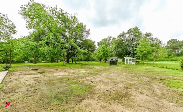 view of yard with fence, an outbuilding, and a shed