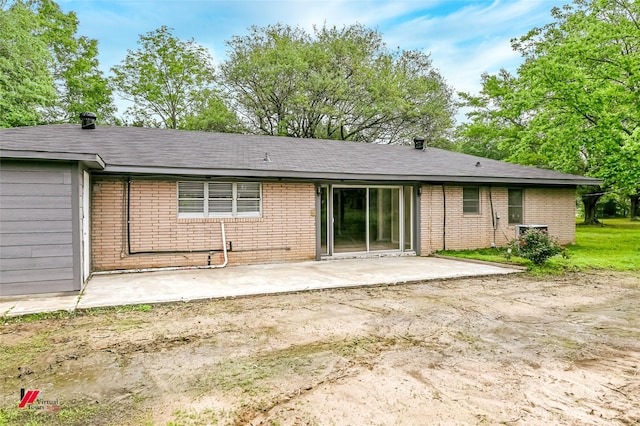 rear view of property with brick siding and a patio area