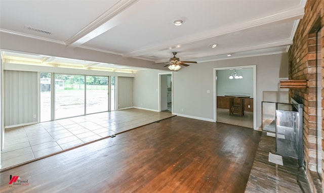 unfurnished living room featuring visible vents, wood finished floors, a fireplace, beamed ceiling, and baseboards