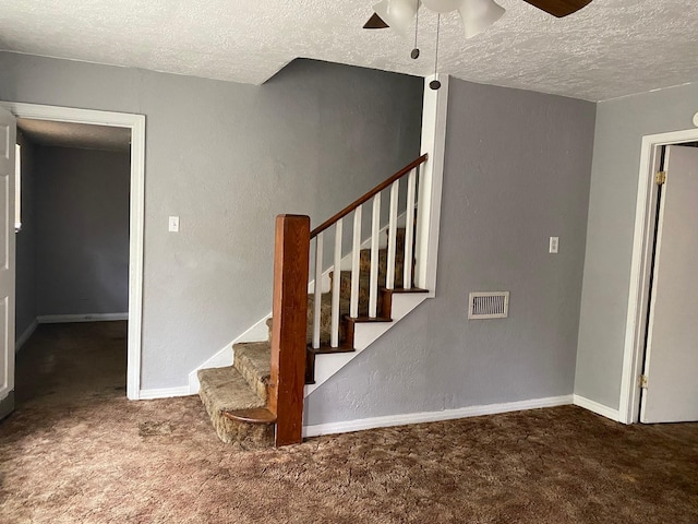 stairs with carpet floors, a ceiling fan, a textured ceiling, and visible vents