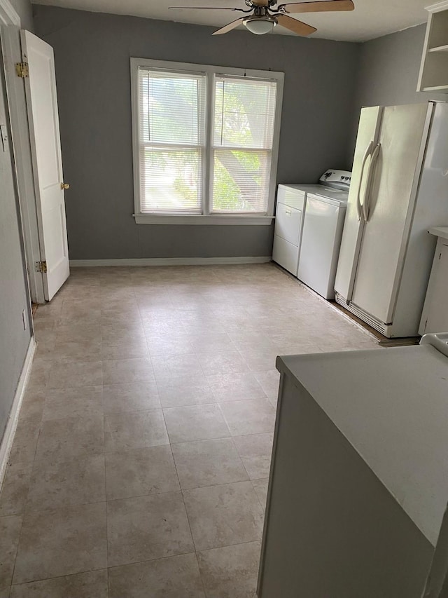 laundry area with laundry area, baseboards, a ceiling fan, independent washer and dryer, and light tile patterned floors