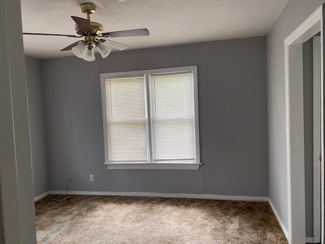 empty room with baseboards, ceiling fan, and carpet