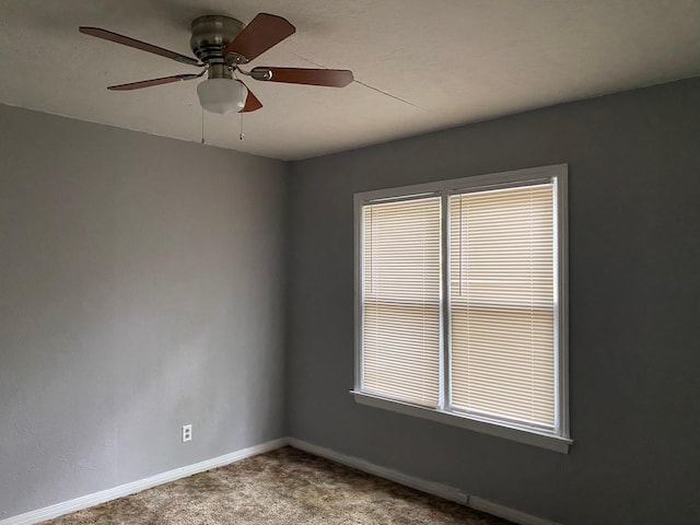 empty room featuring baseboards, ceiling fan, and carpet