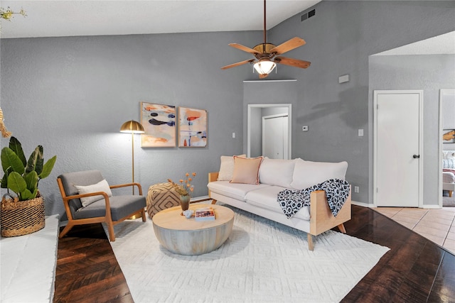 living room with visible vents, wood finished floors, baseboards, high vaulted ceiling, and a ceiling fan