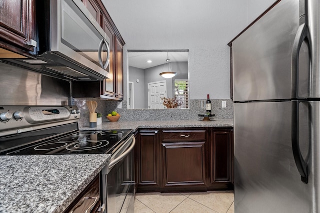 kitchen with decorative backsplash, dark brown cabinets, light stone counters, appliances with stainless steel finishes, and light tile patterned floors