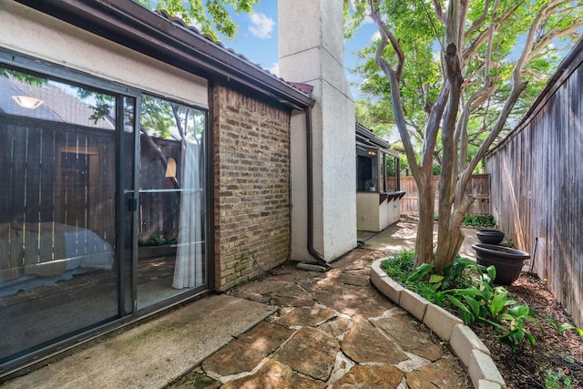 exterior space with fence, a patio, stucco siding, a chimney, and brick siding