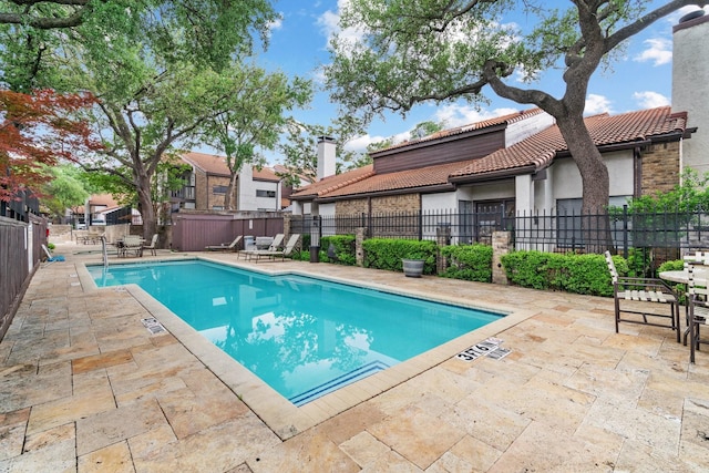 community pool featuring a patio and fence private yard