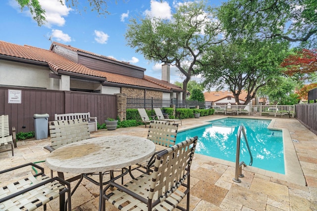 pool featuring fence and a patio area