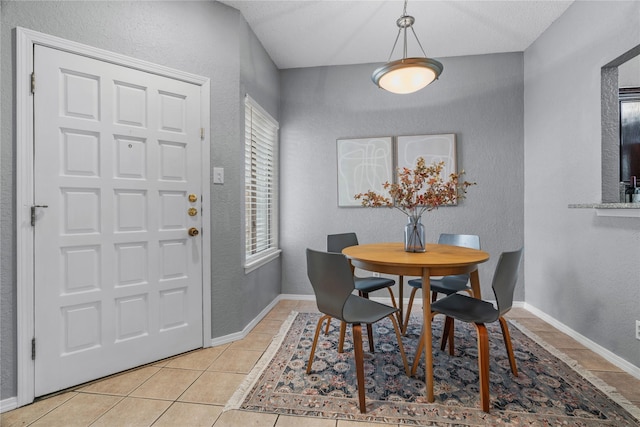 dining room with plenty of natural light, a textured wall, and light tile patterned floors