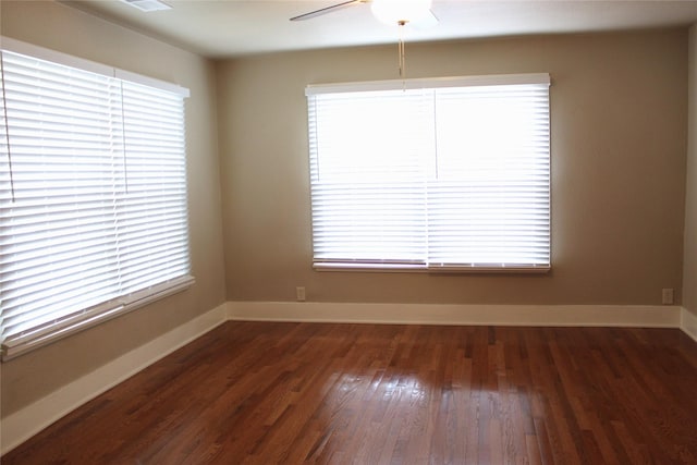 spare room with baseboards, ceiling fan, and wood finished floors