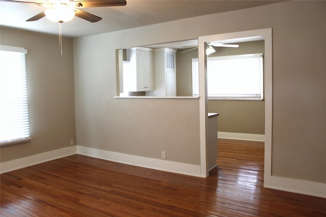 spare room featuring a ceiling fan, baseboards, and wood finished floors