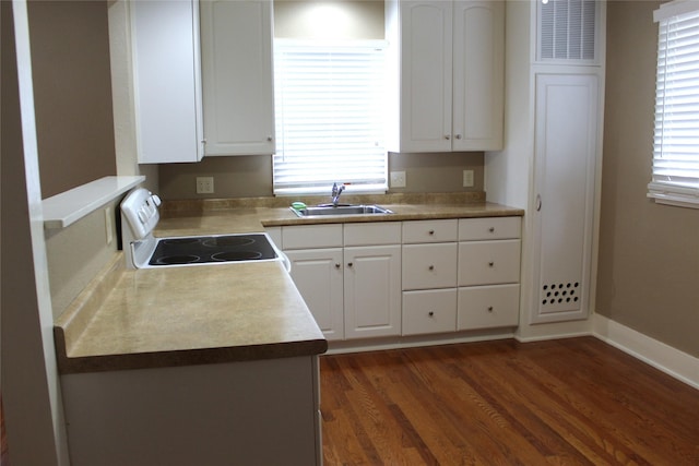kitchen featuring baseboards, white electric range oven, white cabinets, a sink, and dark wood finished floors