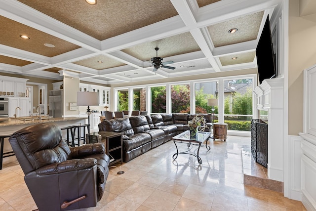 living room with ceiling fan, a healthy amount of sunlight, and coffered ceiling