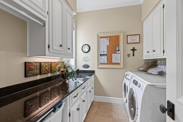 laundry room featuring washing machine and clothes dryer, crown molding, cabinet space, a sink, and baseboards