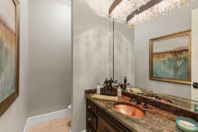 half bath with vanity, toilet, baseboards, tile patterned floors, and a notable chandelier