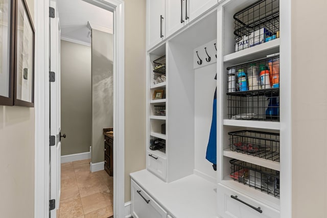 mudroom featuring crown molding, light tile patterned flooring, and baseboards