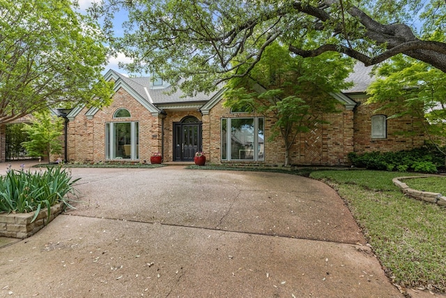 view of front of home with brick siding and a shingled roof