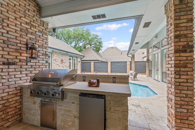 view of patio / terrace featuring an outdoor kitchen and a grill